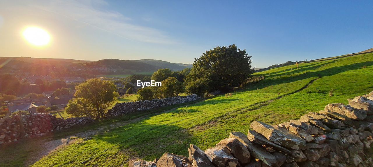 landscape, environment, sky, nature, scenics - nature, land, hill, sun, rural scene, plant, beauty in nature, sunlight, field, valley, mountain range, agriculture, tree, autumn, rural area, travel, tranquility, no people, architecture, sunbeam, sunset, panoramic, flower, outdoors, environmental conservation, travel destinations, crop, tranquil scene, summer, lens flare, sunny, forest, tourism, farm, social issues, grass, building, blue, non-urban scene, green, food and drink, idyllic, leaf, plateau, cloud, day, house