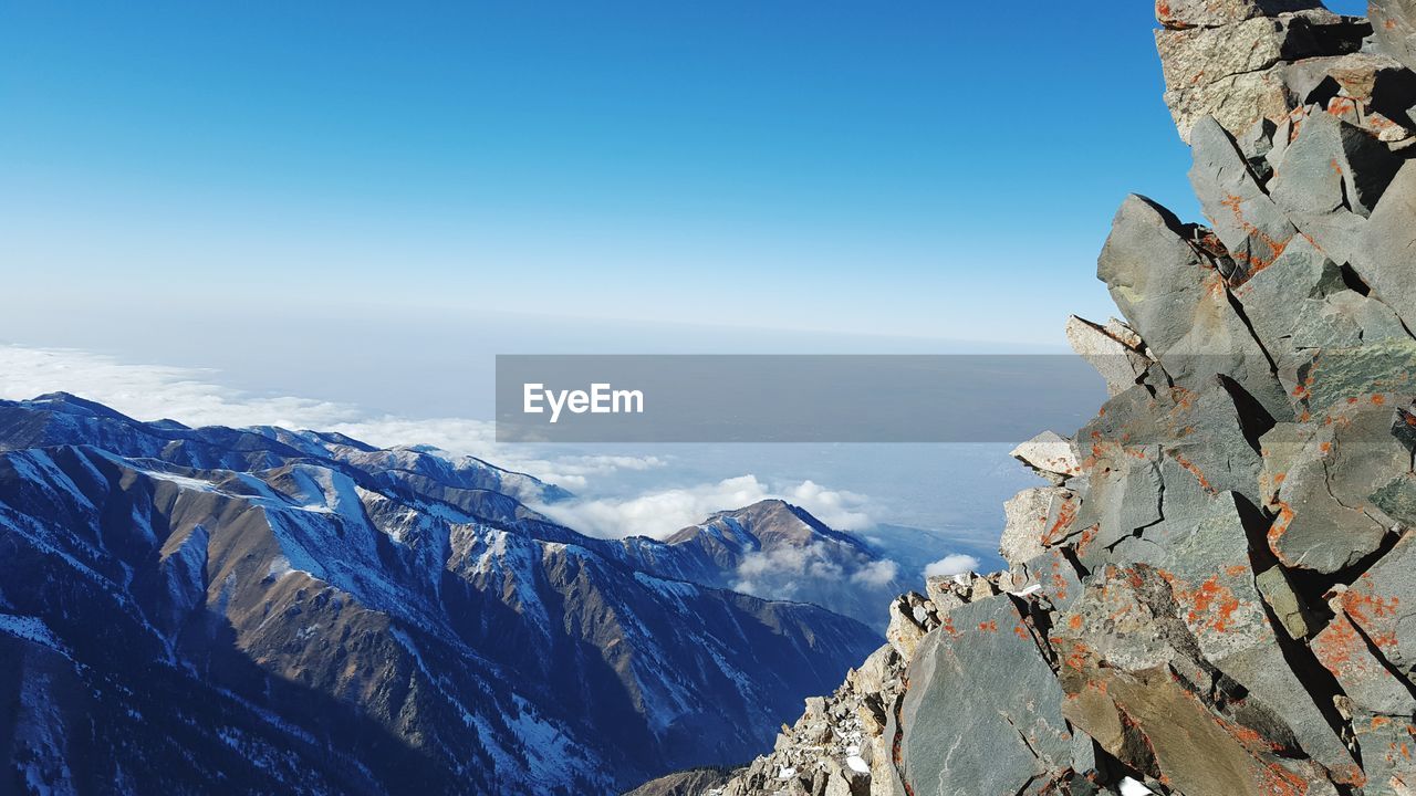 Scenic view of mountains against blue sky