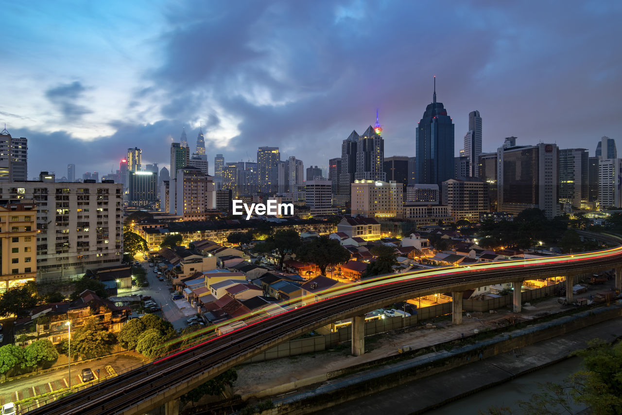 Aerial view of illuminated buildings in city against sky