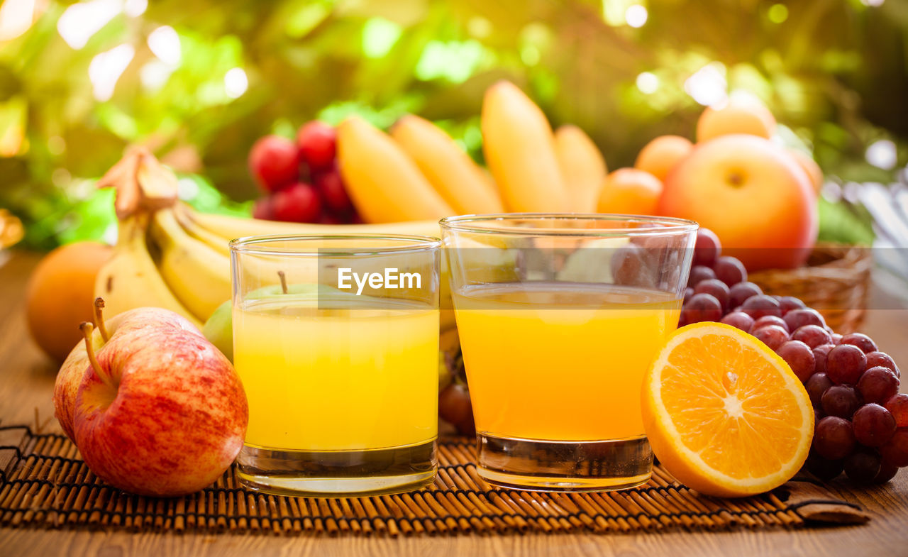 CLOSE-UP OF ORANGE FRUITS IN GLASS ON TABLE