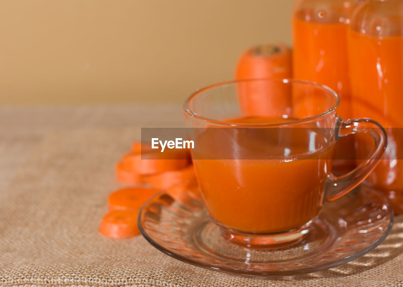 CLOSE-UP OF ORANGE DRINK ON TABLE