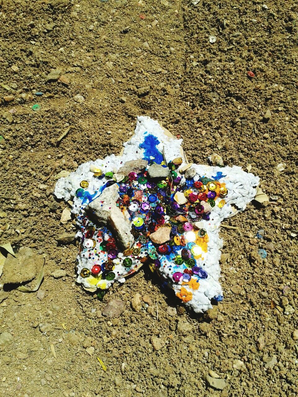 High angle view of multi colored sequins on beach