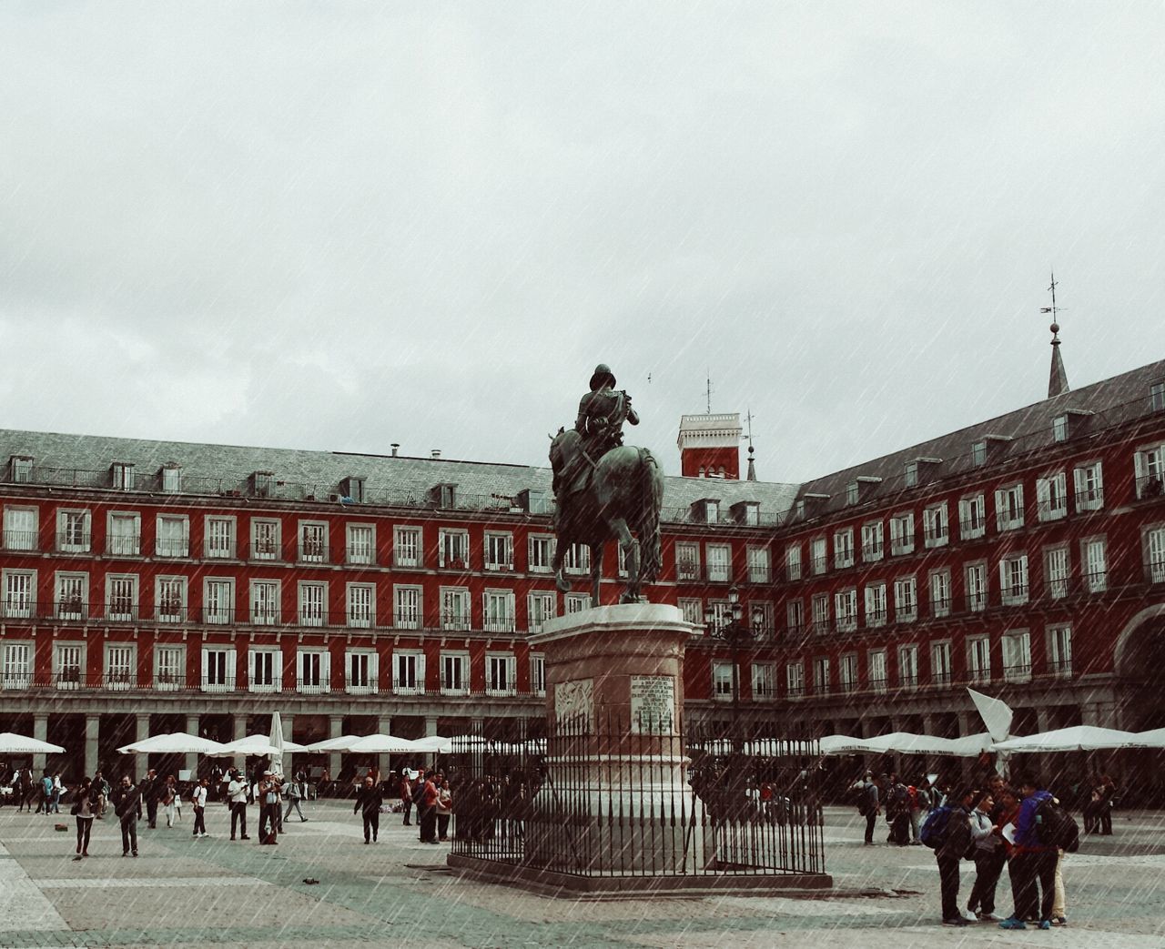 Statue at town square against cloudy sky
