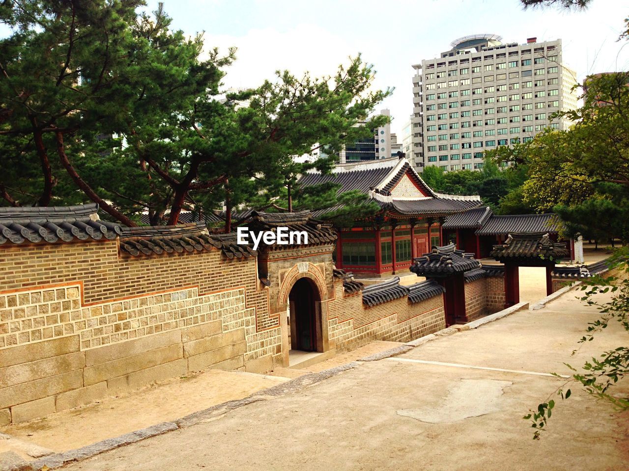 Facade of historic palace by modern building against sky