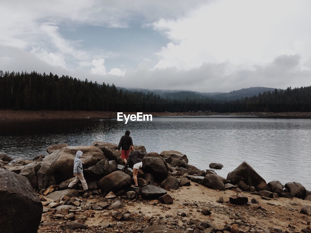 Rear view of people overlooking calm lake