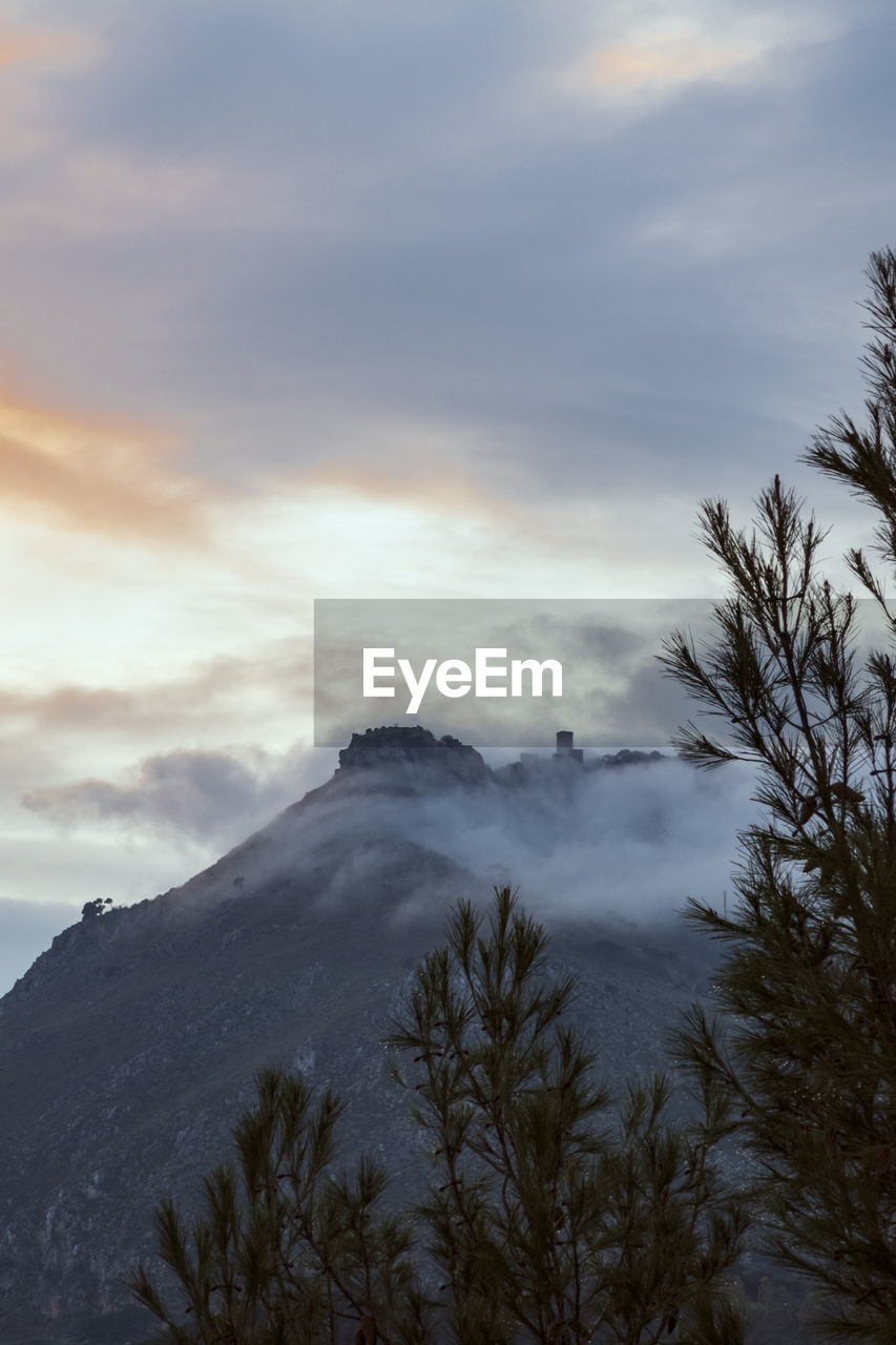 Scenic view of mountains against sky in sunset whit fog