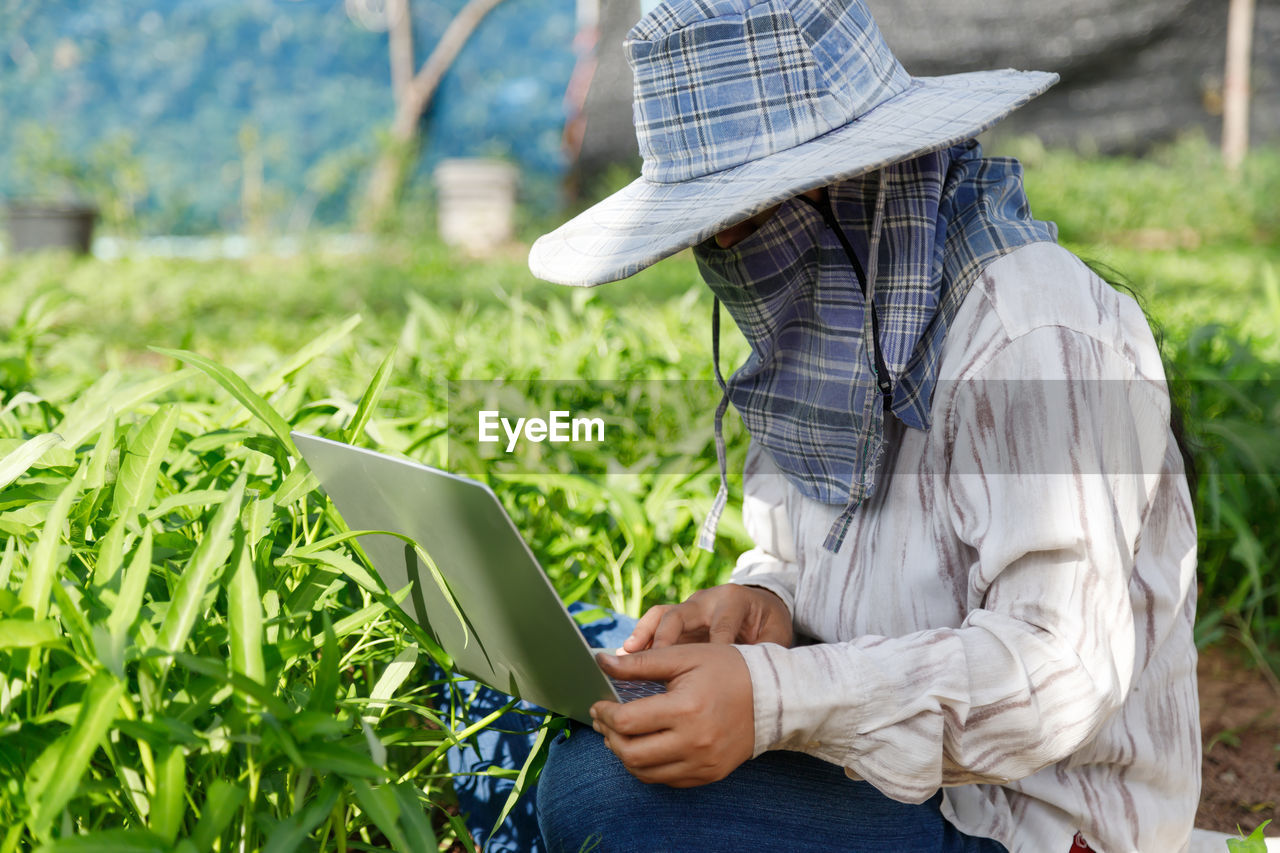 Side view of woman using mobile phone in field