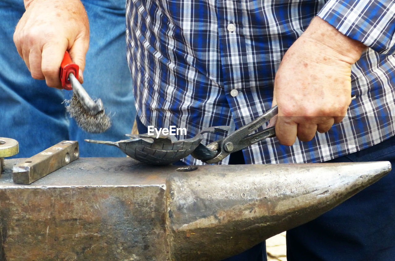 Midsection of man working in workshop