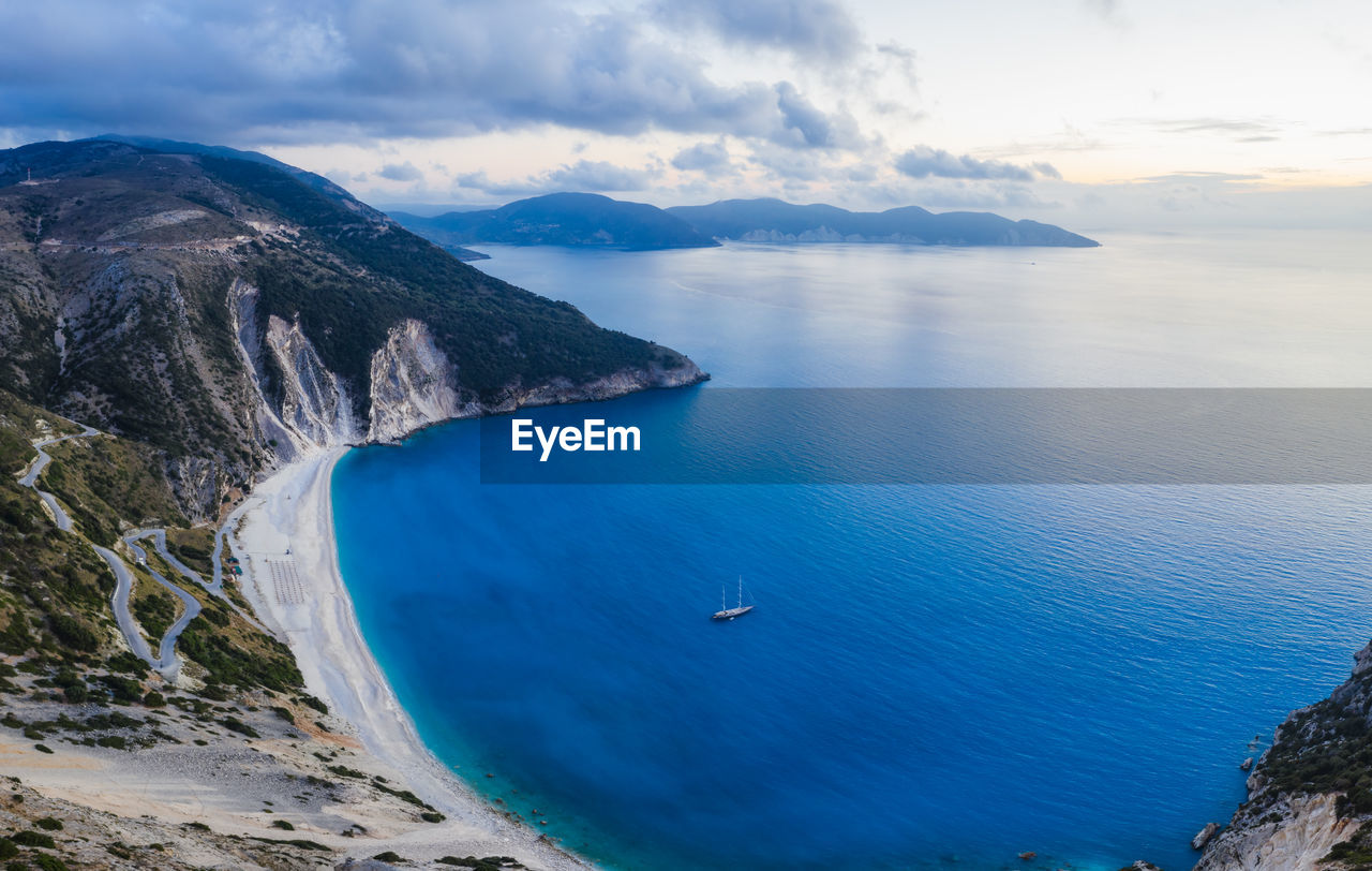 HIGH ANGLE VIEW OF SAILBOATS ON SEA AGAINST MOUNTAINS