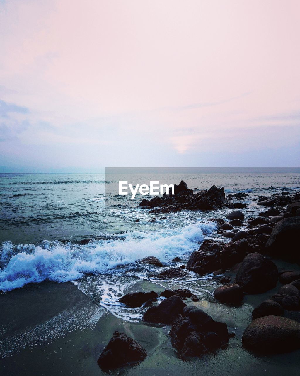 ROCKS IN SEA AGAINST SKY