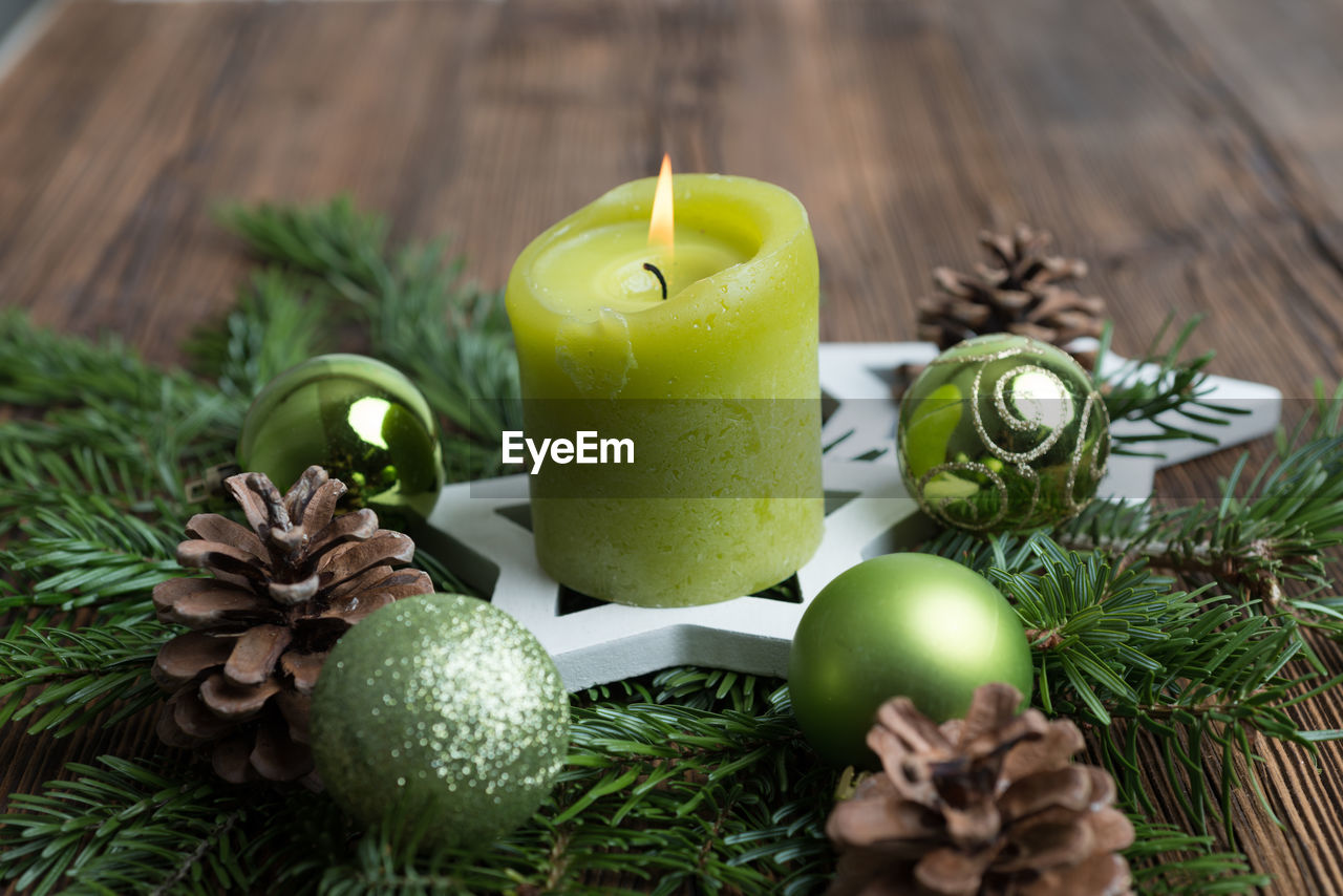 Close-up of lit candle on wreath