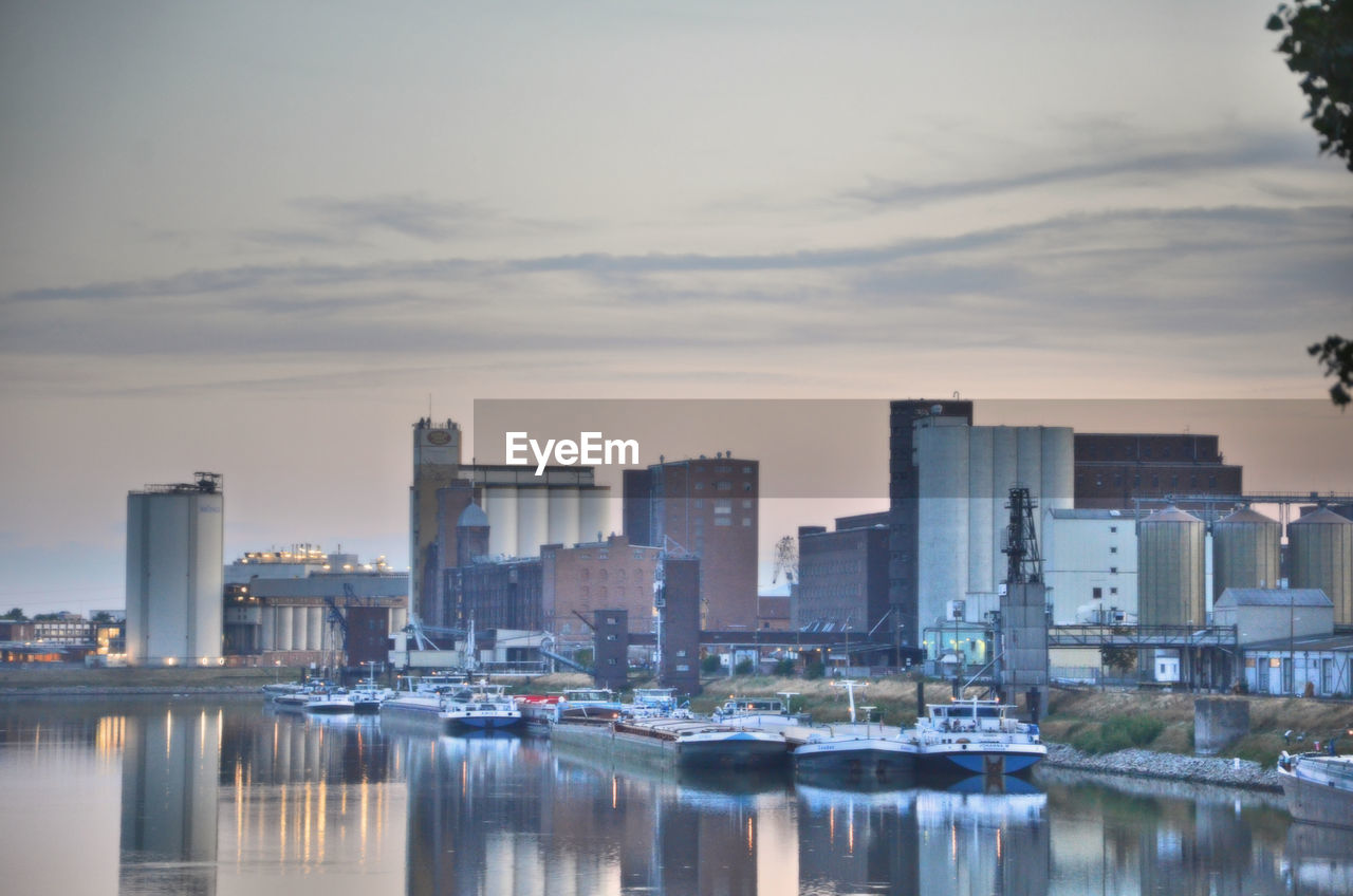 Reflection of buildings in city at sunset