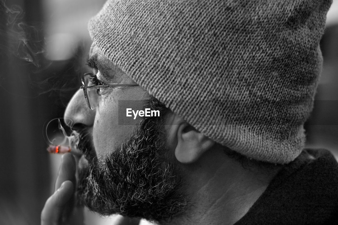 Close-up of bearded man smoking