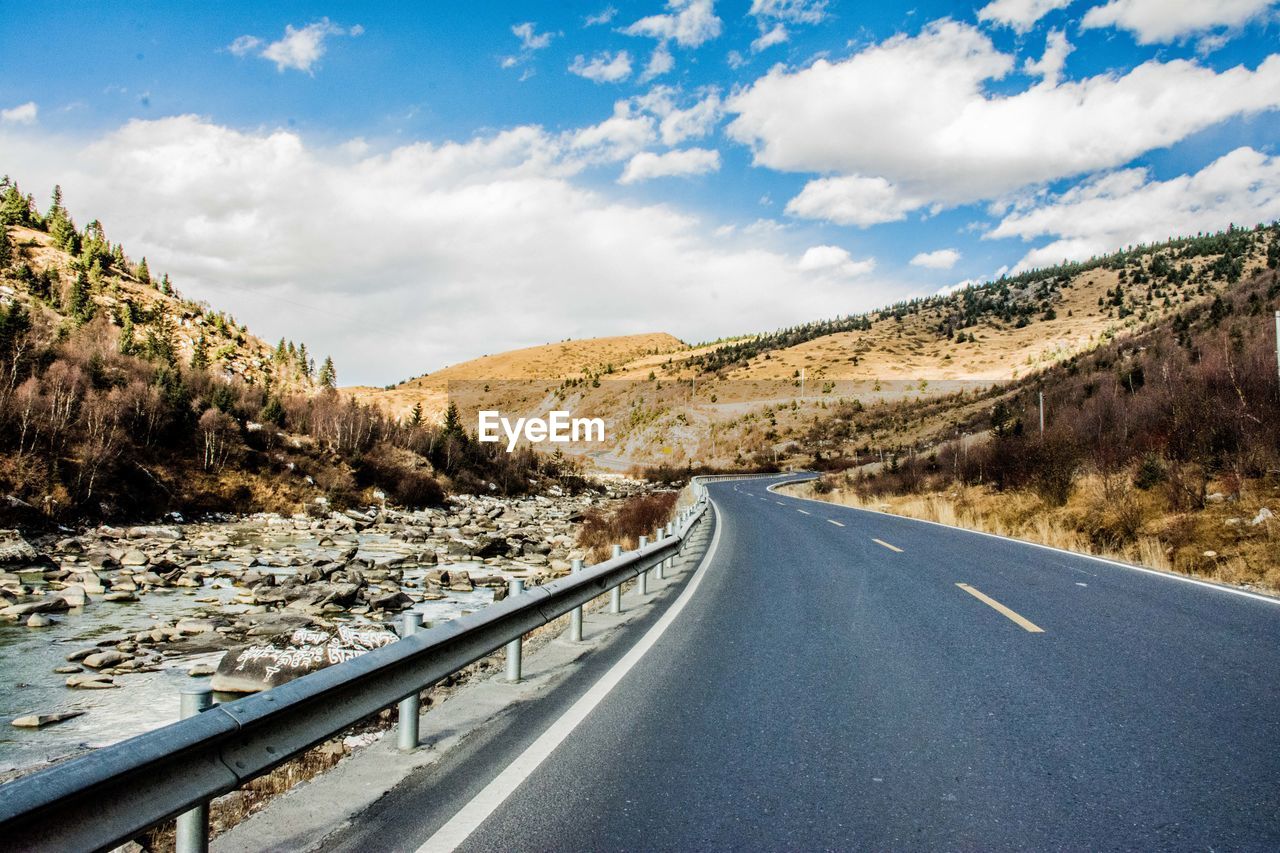 Diminishing perspective of empty road amidst mountains against sky