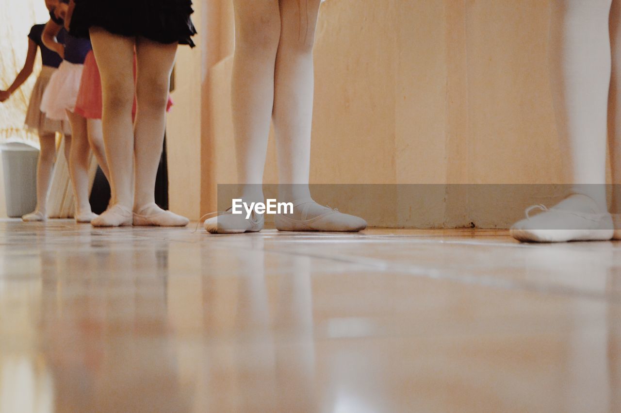 Low section of ballet dancers standing on floor