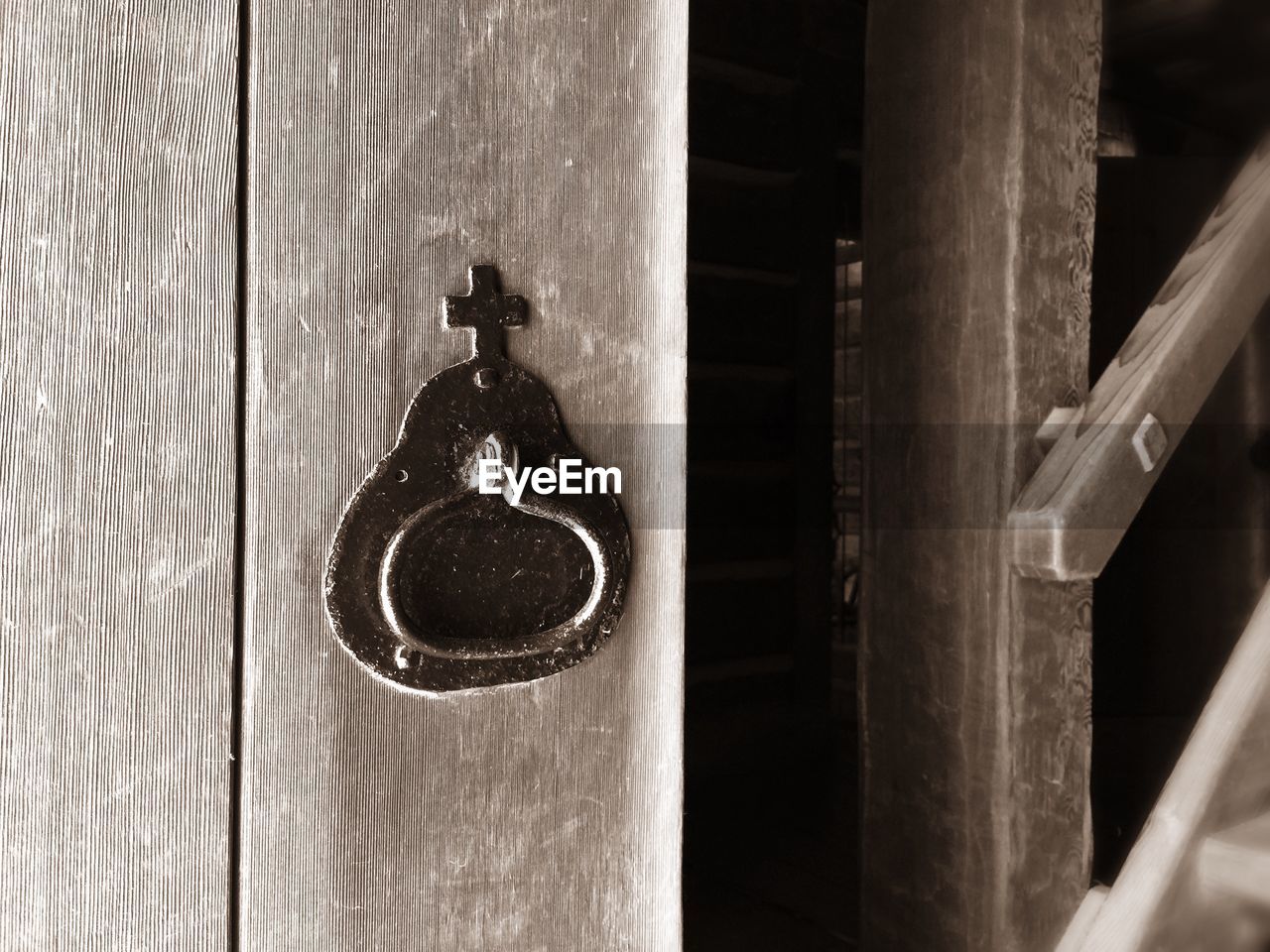 Metallic cross shape mounted on wooden door