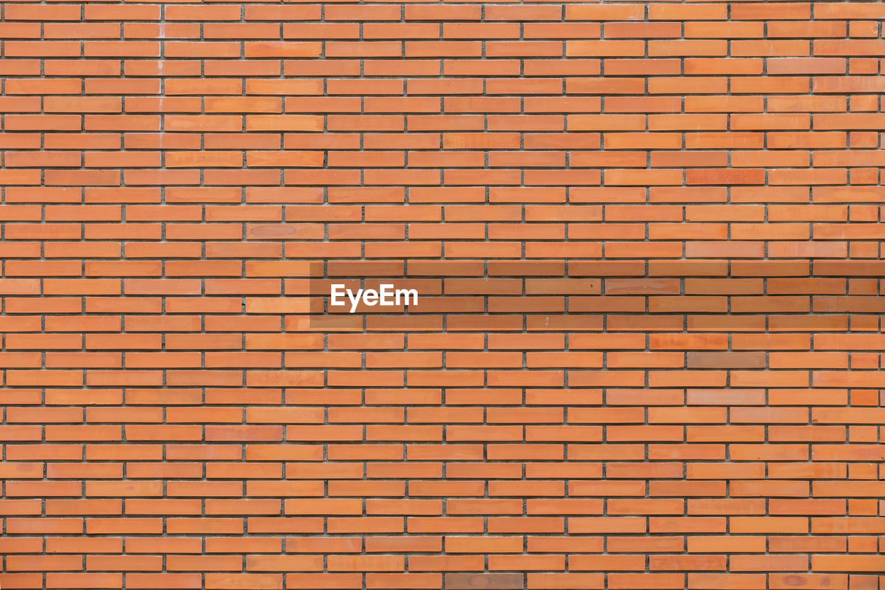 FULL FRAME SHOT OF BRICK WALL AGAINST BUILDING