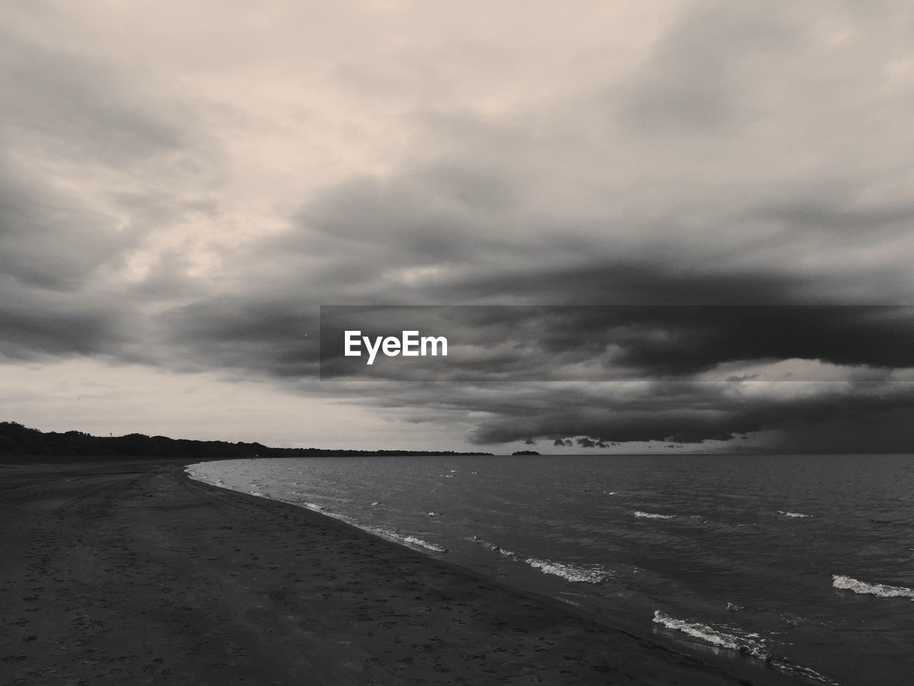 Scenic view of sea against cloudy sky at dusk