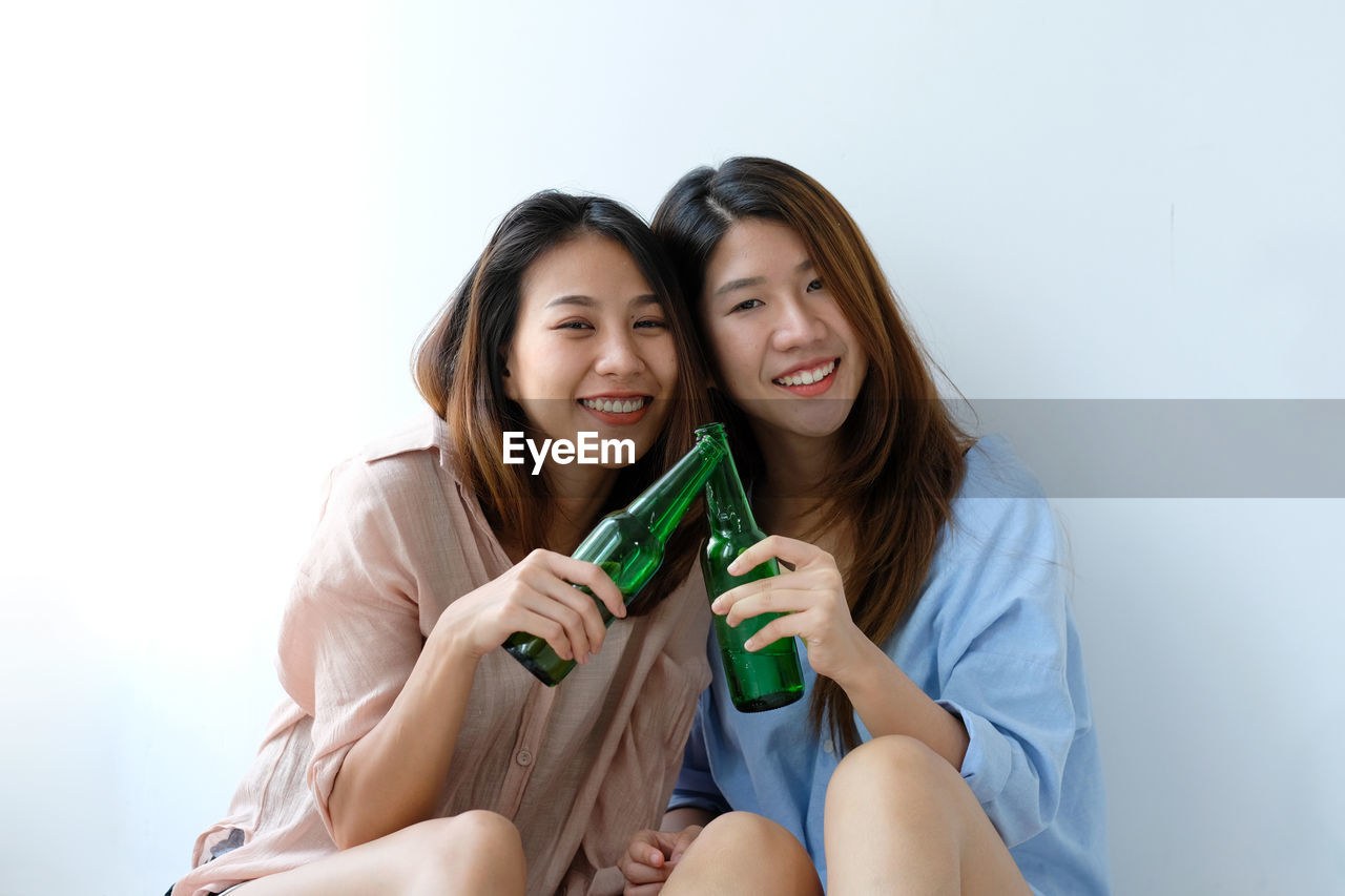 Portrait of lesbian couple holding beer bottles