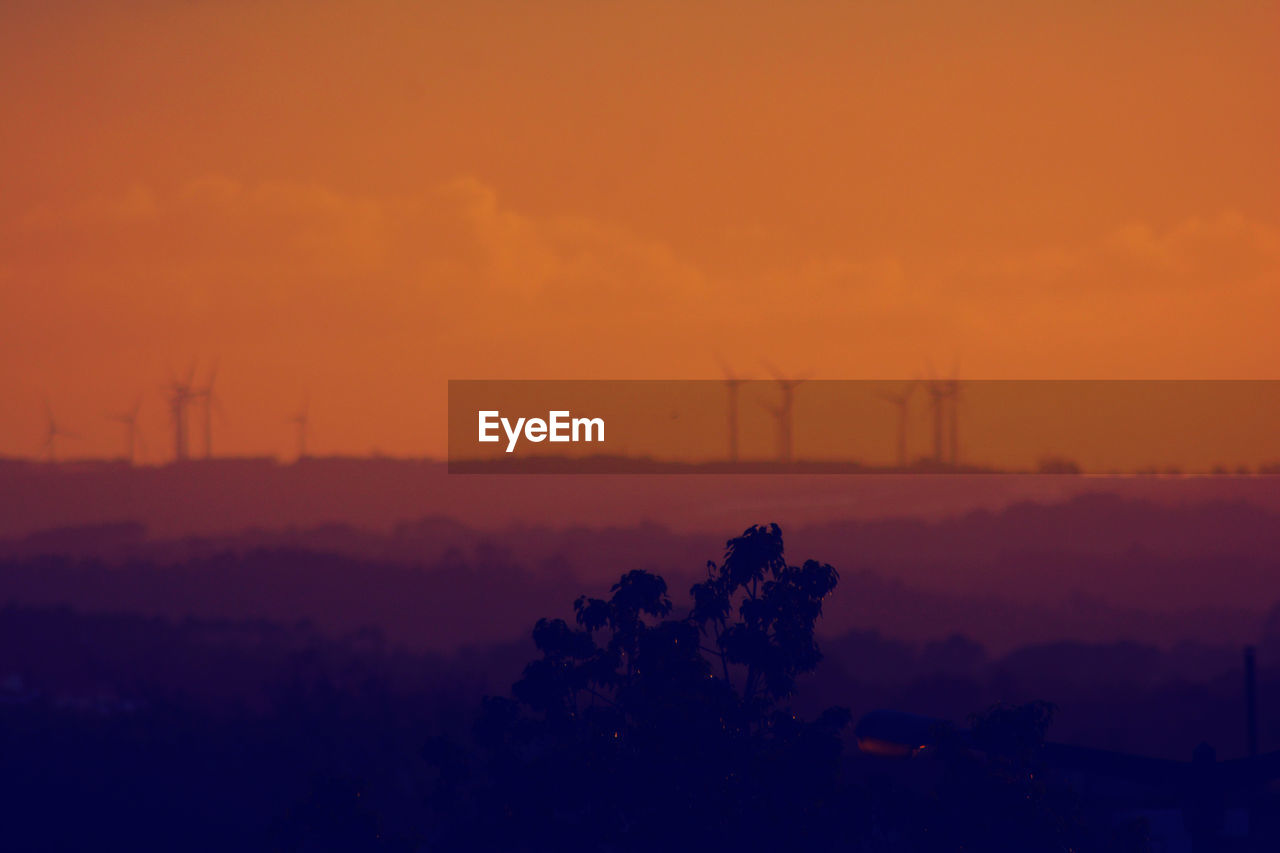 Scenic view of silhouette landscape against orange sky