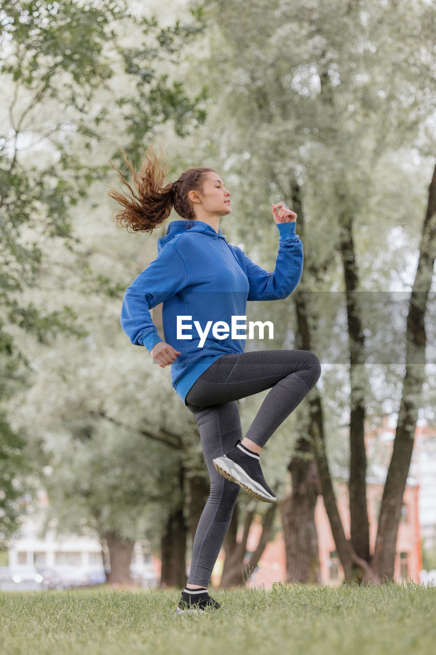 European woman does sports in a park or a public place. warm-up and jogging in the fresh air