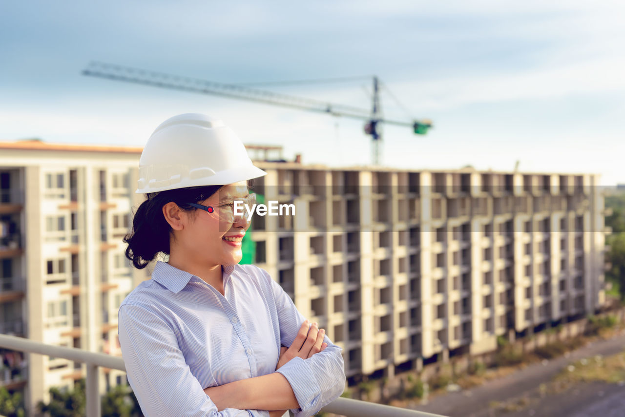 Female engineer looking away while standing at construction site