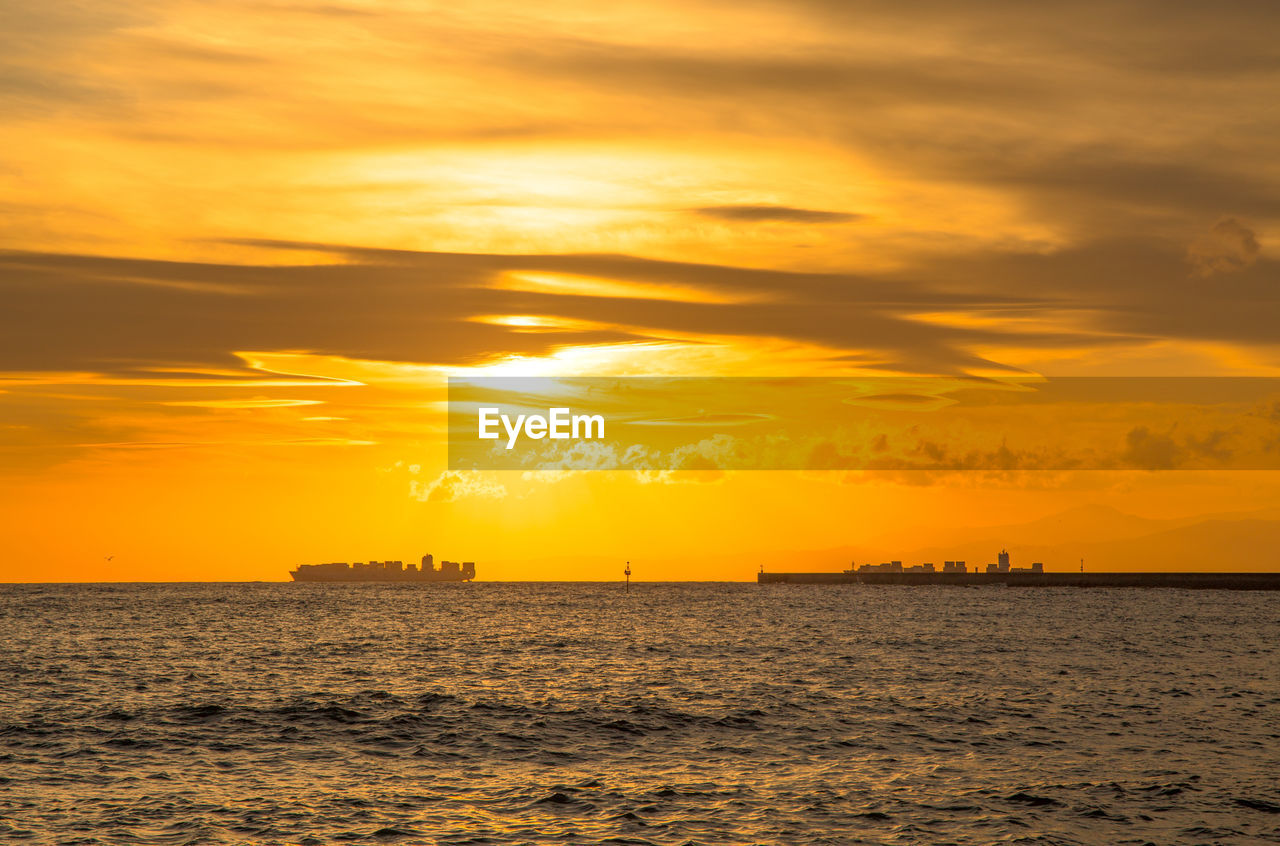 SCENIC VIEW OF SEA AGAINST SKY AT SUNSET