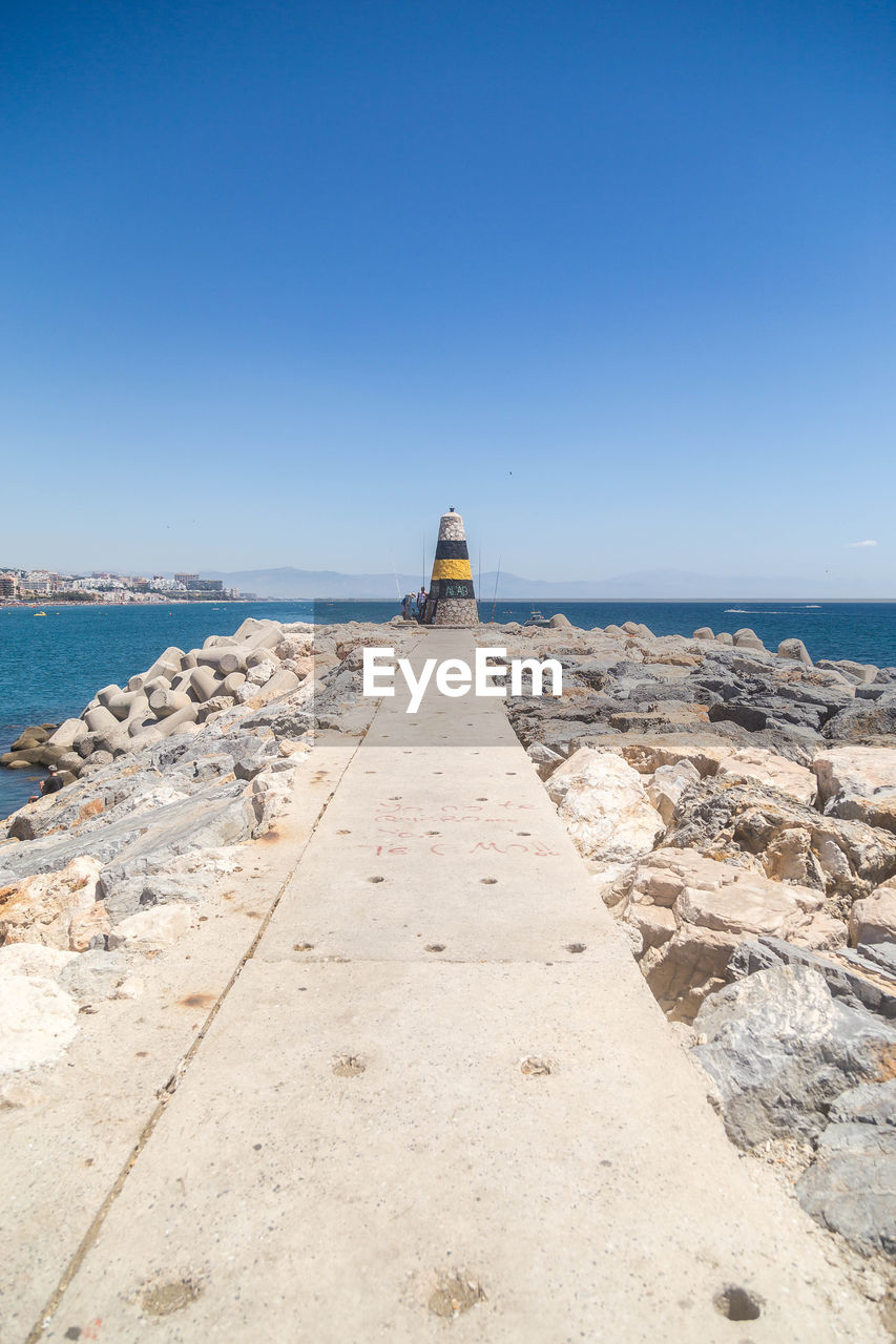 Scenic view of beach against clear blue sky