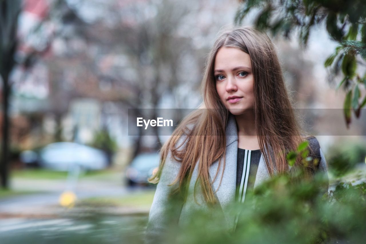 Portrait of young woman with long hair in city