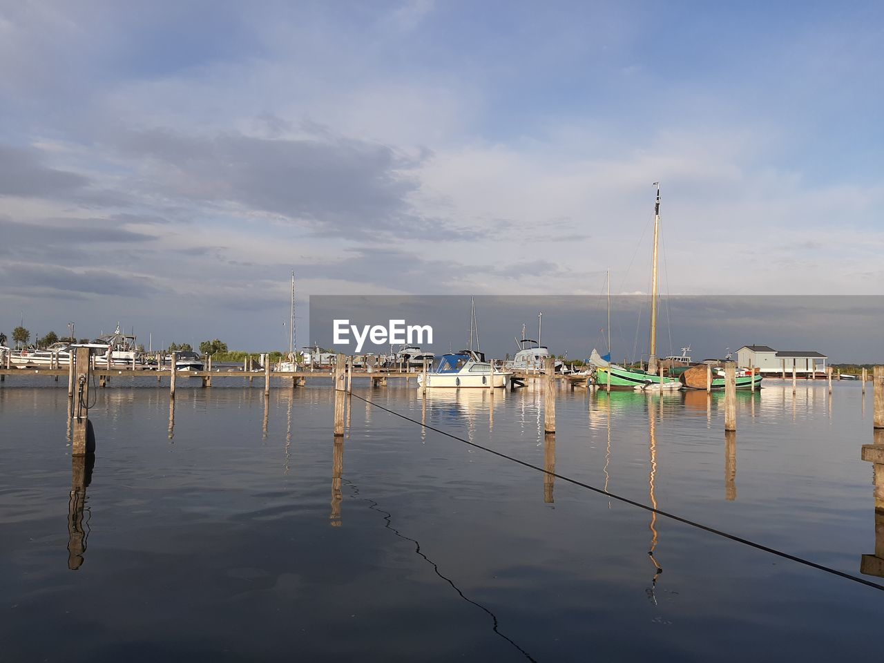 SAILBOATS IN HARBOR AGAINST SKY