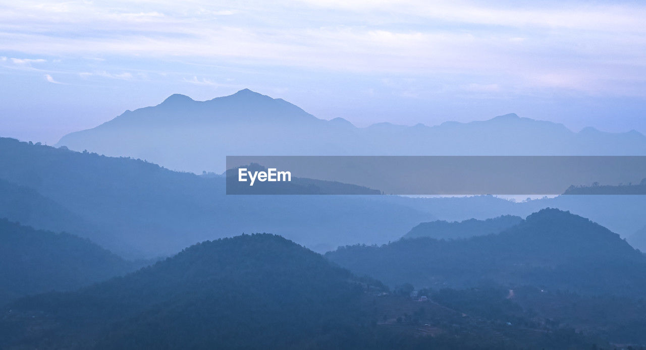 mountain, environment, landscape, scenics - nature, mountain range, fog, nature, beauty in nature, sky, land, ridge, travel, cloud, tranquility, no people, mountain peak, outdoors, forest, wilderness, summit, travel destinations, plateau, tree, morning, tranquil scene, twilight, blue, sun, tourism, plant, non-urban scene, valley, dawn, sunlight