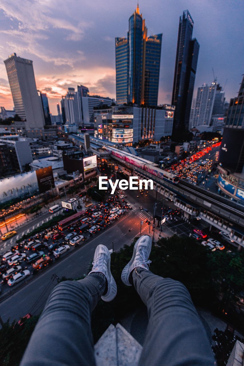 High angle view of person sitting on building terrace against cityscape at night