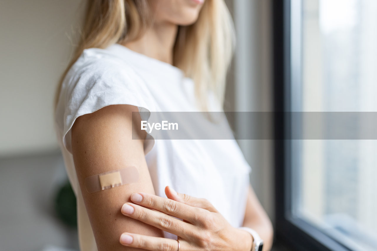 Midsection of woman with bandage on hand