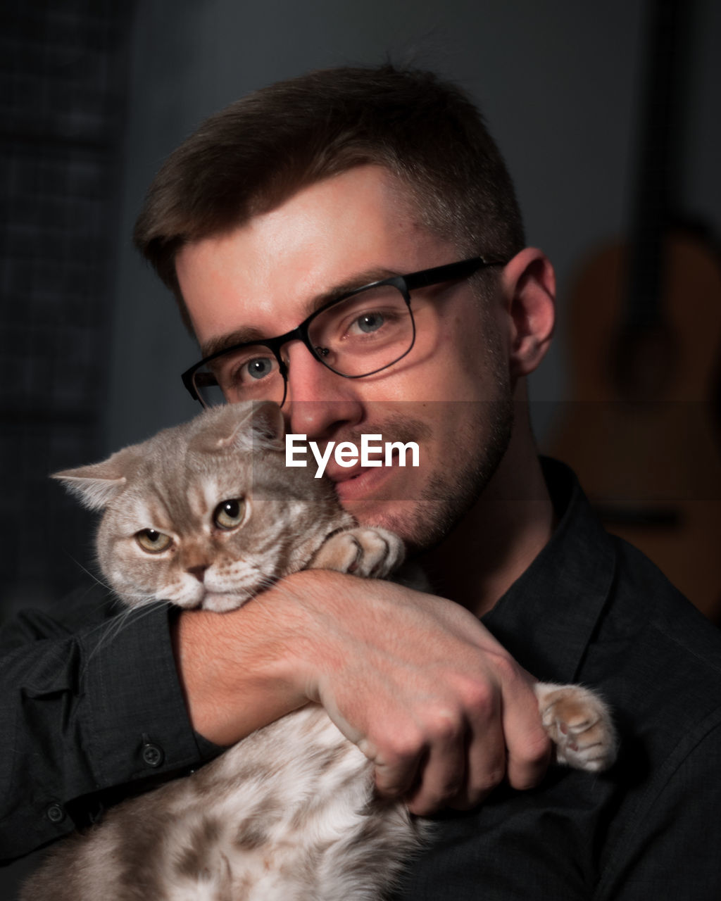 PORTRAIT OF YOUNG MAN WITH CAT