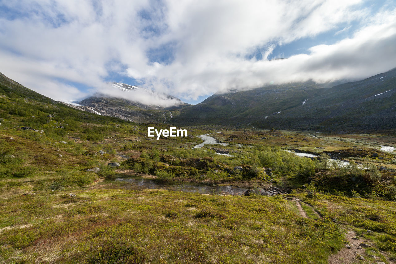 Scenic view of mountains against cloudy sky