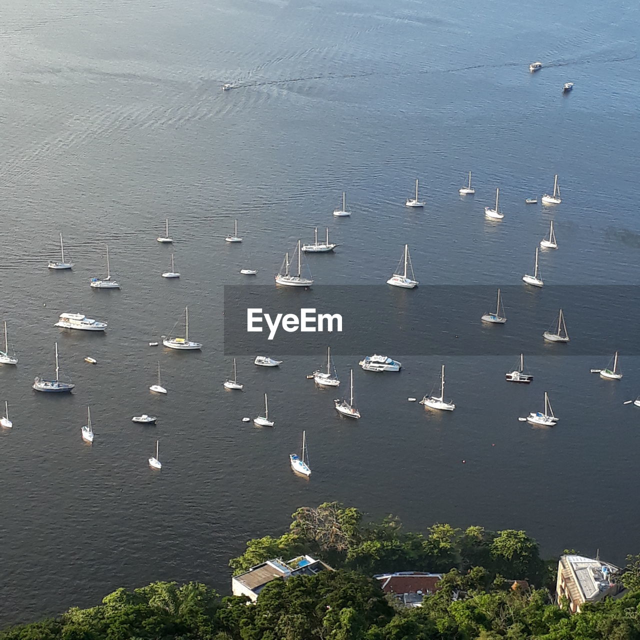 HIGH ANGLE VIEW OF SAILBOATS IN SEA AGAINST CITY