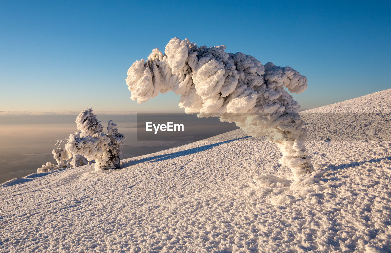 Scenic view of snow covered land against clear sky