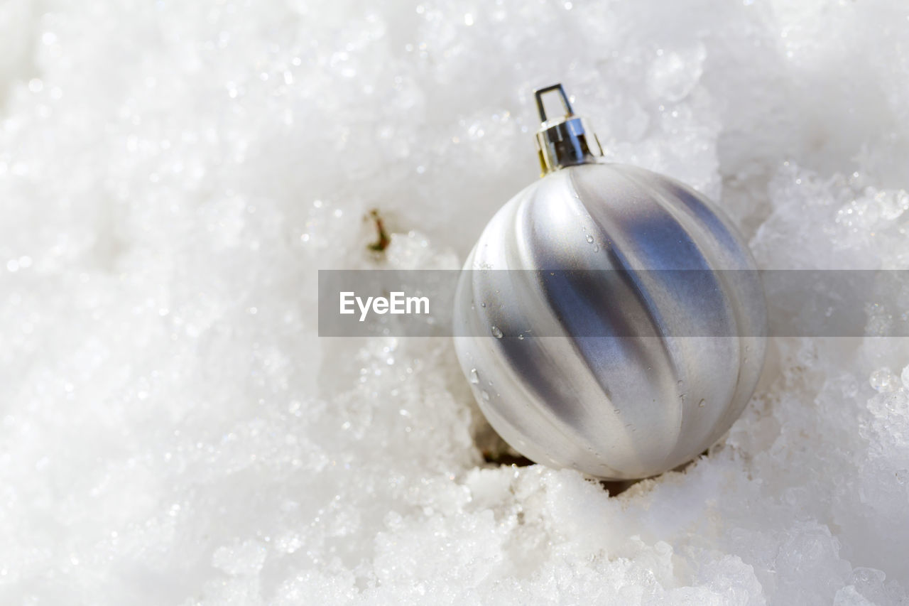 Close-up of christmas bauble on snow