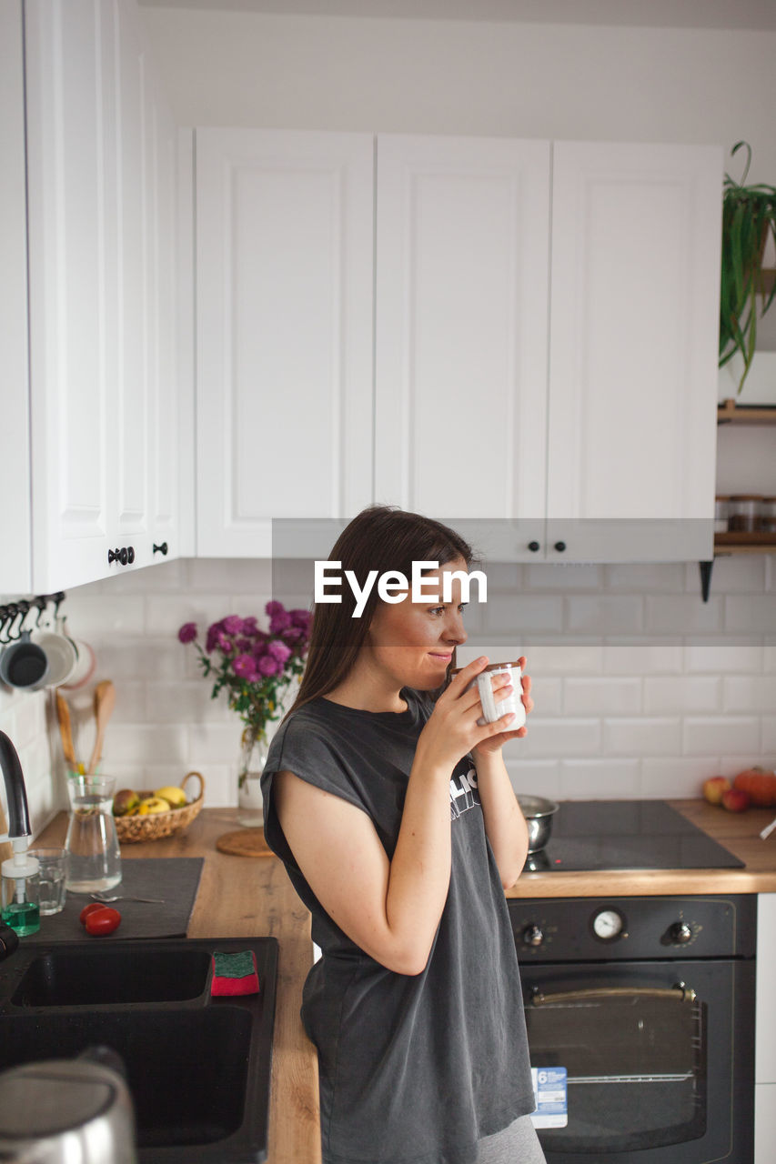 Young woman drinking drink at home