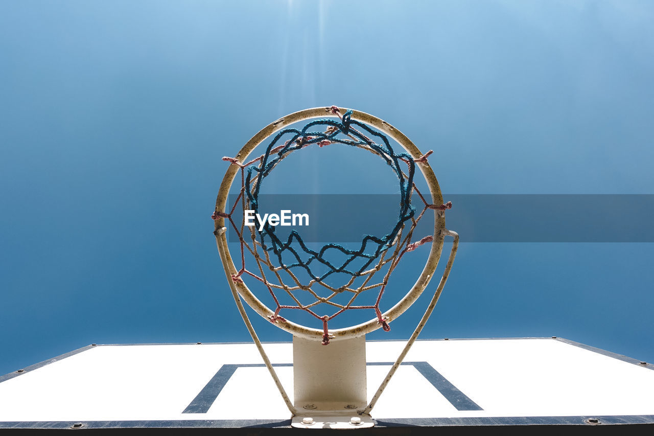 Low angle view of basketball hoop against blue sky