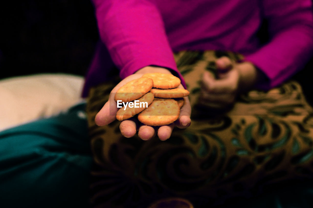 Midsection of woman holding biscuits