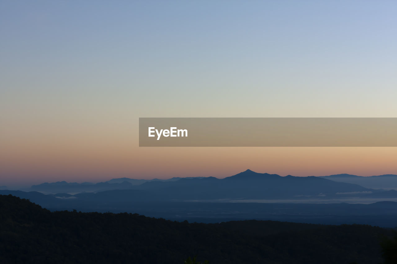 Scenic view of silhouette mountains against sky during sunset