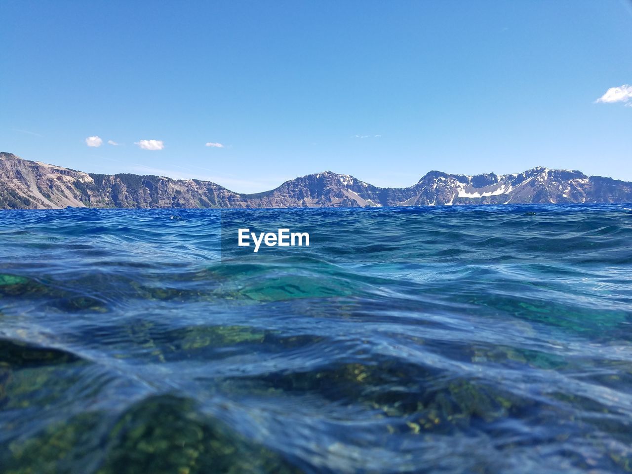 Surface level of crater lake against sky