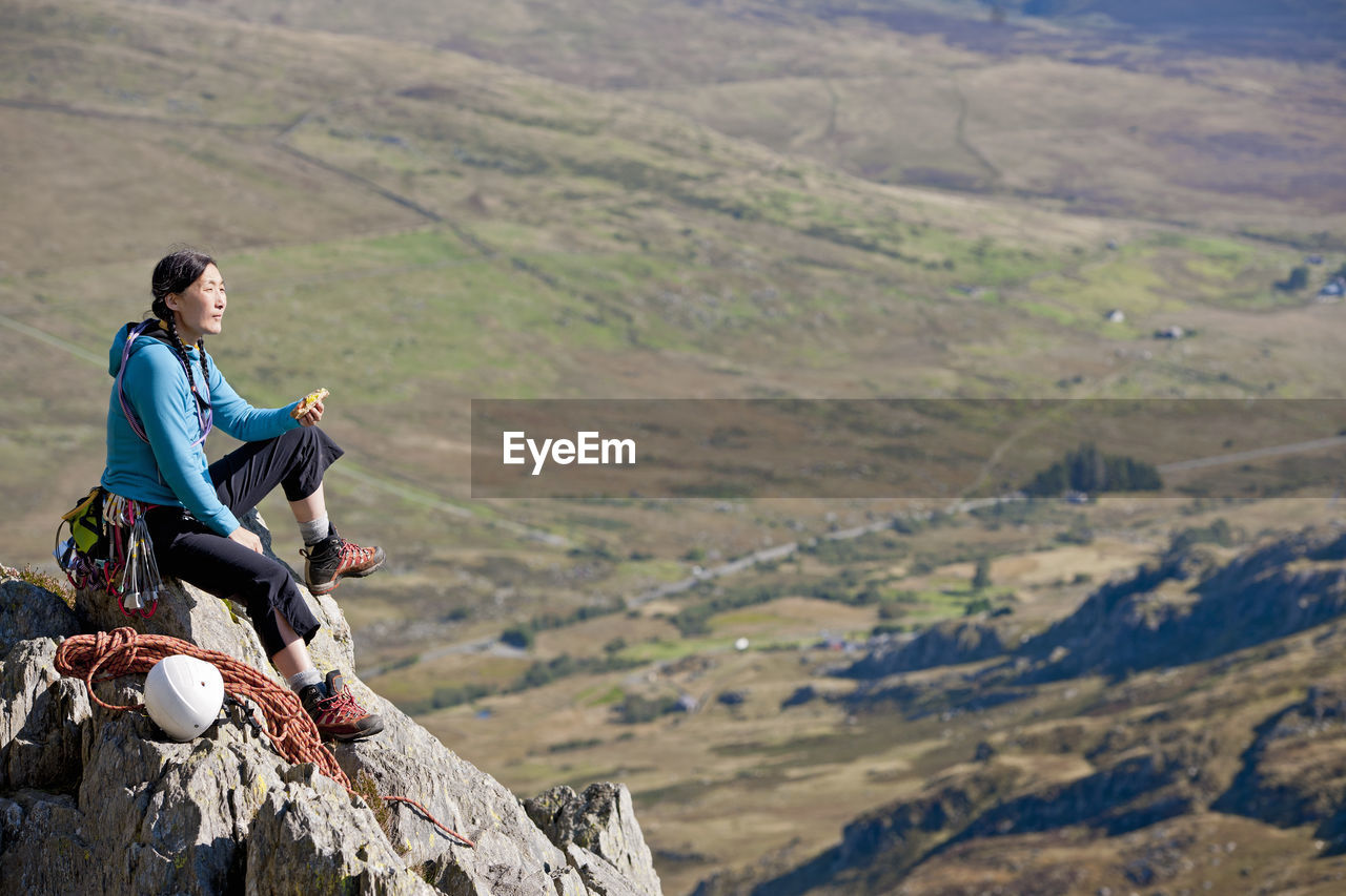 Female rock climber enjoying a sandwich on tryfan in north wales