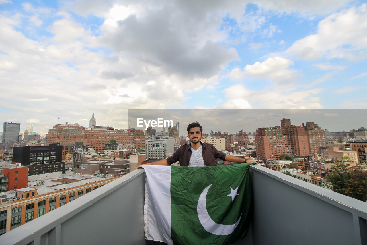 Portrait of man standing holding pakistani flag