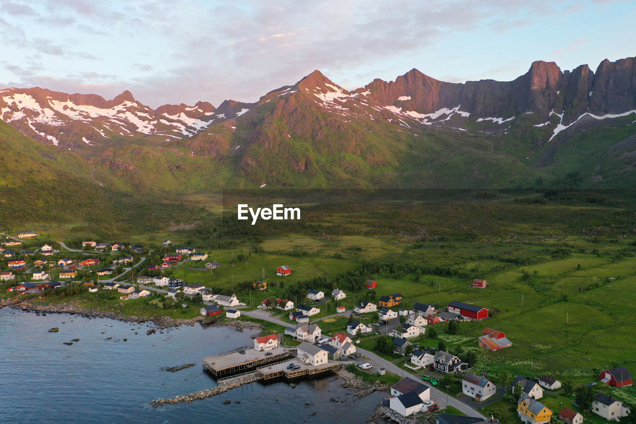 Aerial view of mountains, ocean and a small village during sunset in senja island, norway