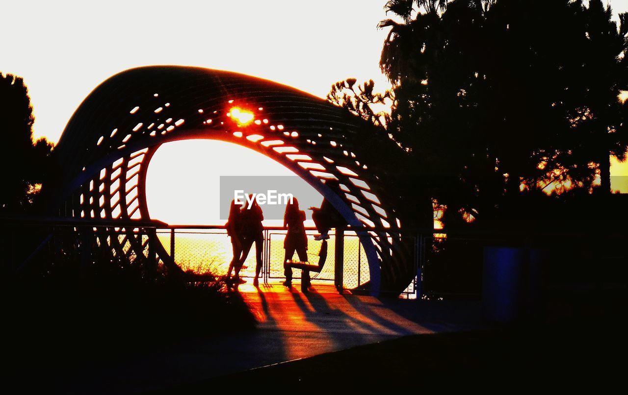 SILHOUETTE PEOPLE WALKING ON ROAD AT NIGHT