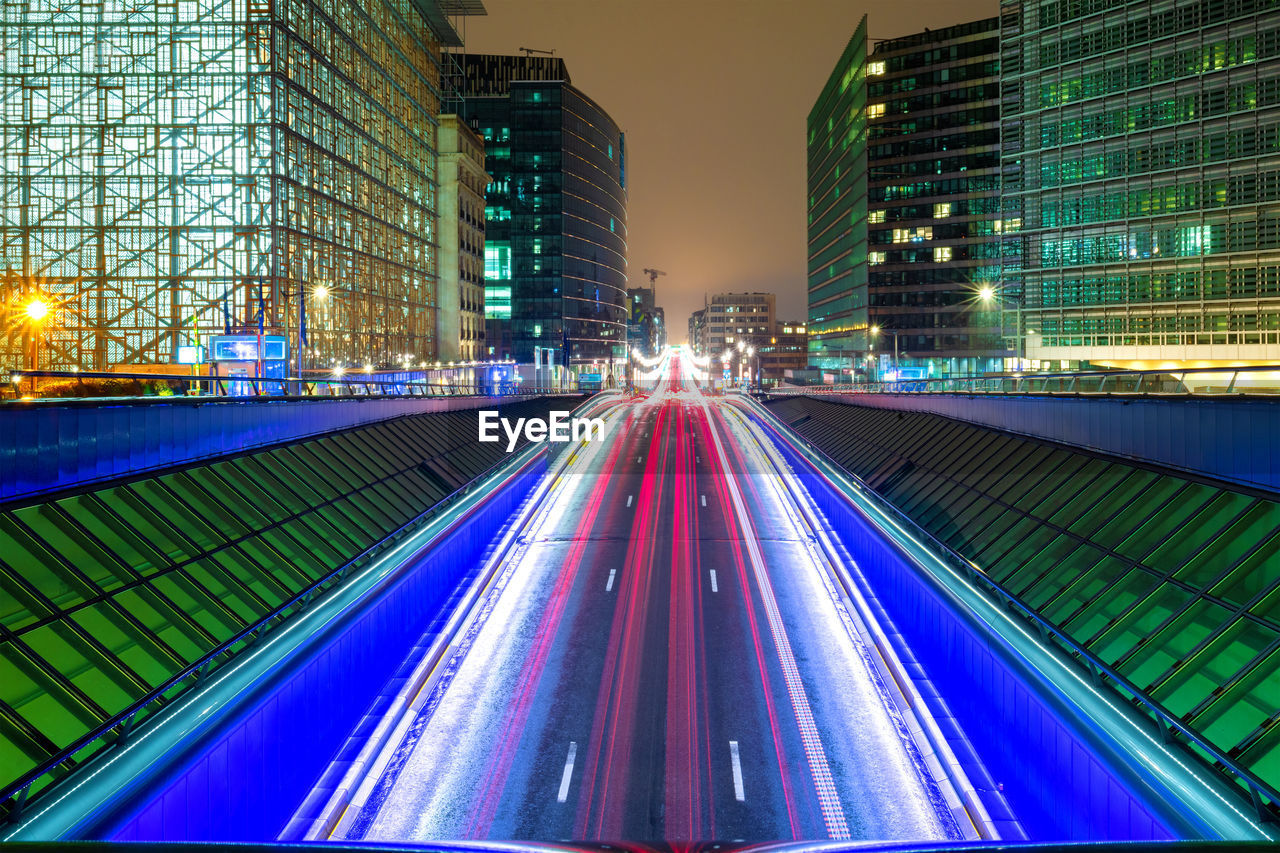 Light trails on illuminated city buildings at night