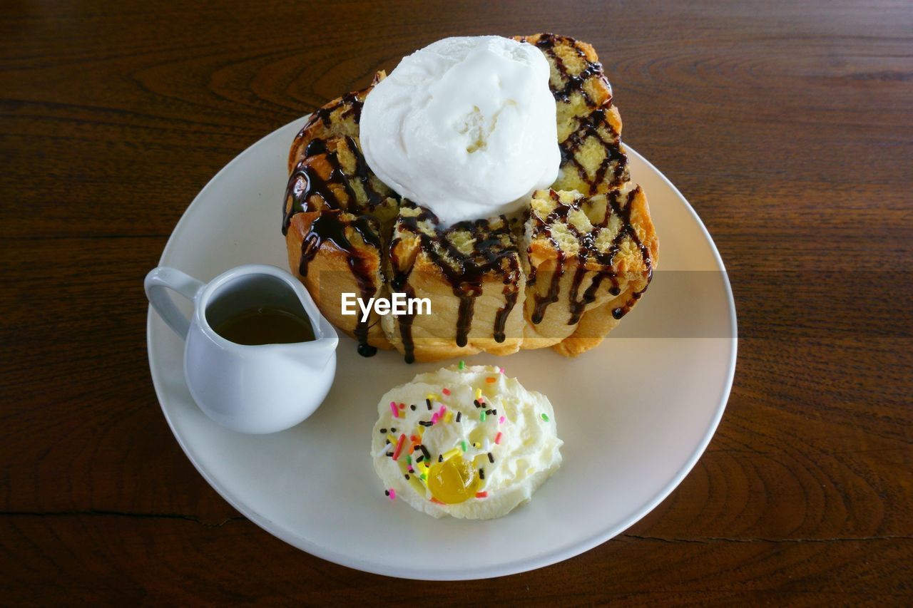 High angle view of dessert served in plate on wooden table