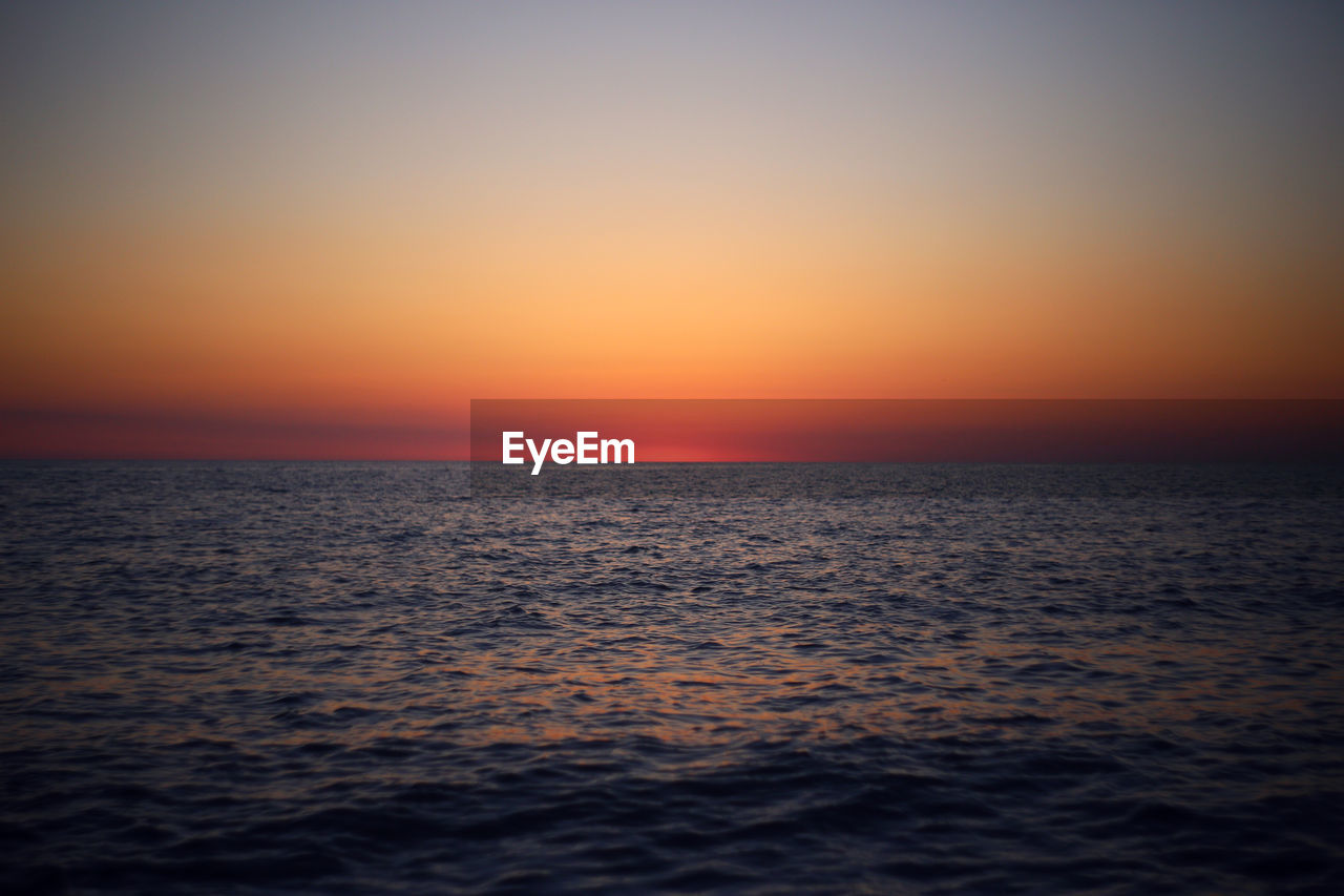 Scenic view of sea against clear sky during sunset